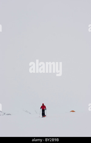 Gletscher-Geologie / Doktorand Ski über den Brady-Gletscher bei Whiteout Blizzard, und ziehen Sie einen Schlitten von geophysikalischen Stockfoto