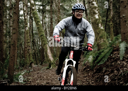 Zwei Mountainbiker aus eine eingleisige Strecke durch den Wald reiten. Stockfoto