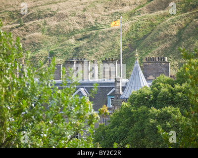 Der Queens Residenz Holyrood Palace, durch die Bäume mit Arthurs Seat im Hintergrund, Edinburgh, Schottland. Stockfoto