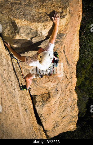 Ein Kletterer greift nach oben auf einem Felsen aus Sandstein in Santa Barbara. Stockfoto