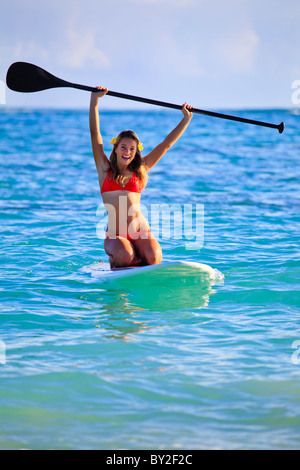 Teenager-Mädchen im roten Bikini am Stand up Paddle Board im Ozean in hawaii Stockfoto