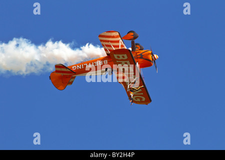 Eine Boeing PT17 Stearman des Breitling-Flügels zu Fuß Kunstflugstaffel Rollen invertiert Stockfoto