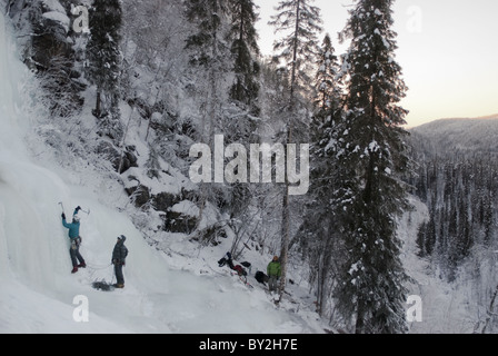 Ein Eiskletterer schwingt seine Axt auf ein Eis fallen mit Korouma, Posio in Lappland, Finnland. Stockfoto