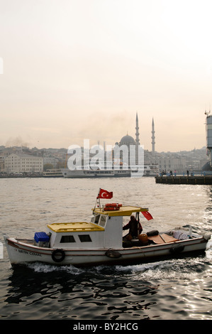 ISTANBUL, Türkei / Türkiye – Boot auf dem Goldenen Horn unter der Galata-Brücke mit der Hidayet-Moschee im Hintergrund. Stockfoto