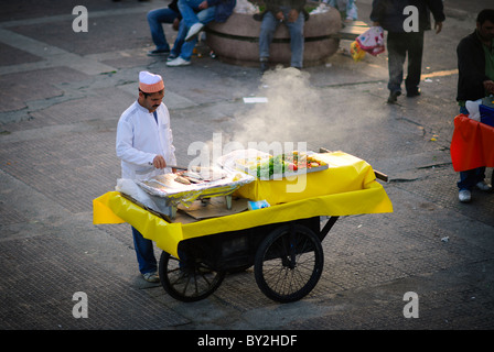 ISTANBUL, Türkei – Ein Straßenverkäufer grillt frischen Fisch auf einem mobilen Wagen auf dem Karakoy Fischmarkt in der Nähe der Galata-Brücke in Istanbul. Diese Händler bereiten typischerweise Balık ekmek (traditionelle Fisch-Sandwiches) zu, ein beliebtes Street Food mit frisch gefangenem Fisch aus lokalen Gewässern. Das Grillen von Fisch entlang der Uferpromenade steht für eine lange kulinarische Tradition in Istanbul. Stockfoto