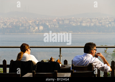 ISTANBUL, Türkei / Türkiye - Touristen genießen ihren türkischen Tee und genießen den Blick über den Bosporus im Gulhane Park neben dem Topkapi Palast. Stockfoto