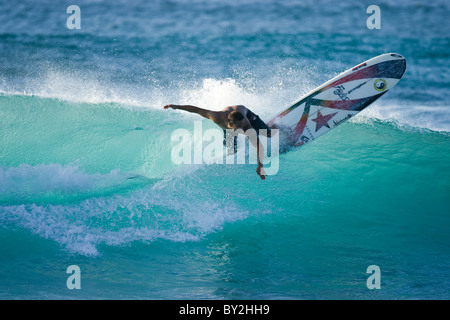 Ein junger Mann, Surfen auf einem Longboard am Rocky Point, auf der Nordküste von Oahu, Hawaii. Stockfoto