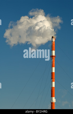 Rauch, Gas und Dampf Wogen aus einem Schornstein vor blauem Himmel. Stockfoto