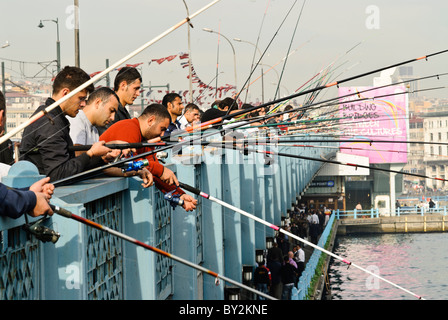 ISTANBUL, Türkei – lokale Fischer säumen das Geländer der historischen Galata-Brücke, die das Goldene Horn überspannt. Die Brücke, die Eminonu mit Karakoy verbindet, ist seit Generationen ein beliebter Angelplatz. Dutzende Angler versammeln sich routinemäßig entlang der oberen Ebene der Brücke, um ihre Linien in die Gewässer unter ihnen zu werfen. Stockfoto