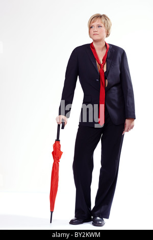 Junge Frau in einem Anzug mit einem Regenschirm Stockfoto