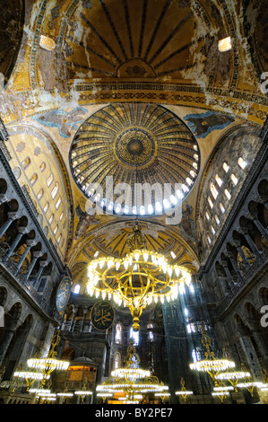 ISTANBUL, Türkei – die große Haupthalle der Hagia Sophia zeigt ihr bemerkenswertes byzantinisches Architekturdesign mit ihrer massiven zentralen Kuppel, die von Pendentiven und Halbkuppeln gestützt wird. Das Innere zeigt sowohl christliche als auch islamische Elemente, darunter byzantinische Mosaike, osmanische Kalligrafie und große osmanische Vogelleuchter. Massive Marmorsäulen und -Tafeln säumen den Raum und demonstrieren die Pracht der architektonischen Technik aus dem 6. Jahrhundert. Stockfoto