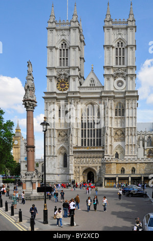 Blick auf Touristen außerhalb der Portland Stone Twin Towers Westfront der berühmten historischen Westminster Abbey London England Stockfoto