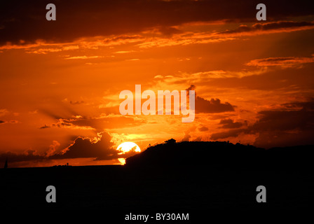 ST. JOHN, US Jungferninseln – Ein atemberaubender karibischer Sonnenuntergang von St. John auf den US Jungferninseln, während die Sonne unter dem Horizont hinter der Silhouette von St. Thomas eintaucht. Der Himmel strahlt in leuchtenden Orange-, Rosa- und Violetttönen aus, die sich von den ruhigen Gewässern der Karibik spiegeln. Stockfoto