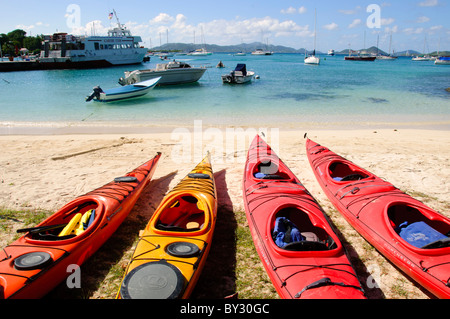 CRUZ BAY, St. John, US Jungferninseln – farbenfrohe Kajaks säumen den Strand von Christian Cove in Cruz Bay, der wichtigsten Stadt und dem Einreisehafen auf St. John auf den US Jungferninseln. Diese lebendigen Wasserfahrzeuge bieten Besuchern die Möglichkeit, die Küste zu erkunden und sich auf Wasserbasis zu entspannen und die beliebten Outdoor-Aktivitäten auf dieser karibischen Insel zu präsentieren. Stockfoto