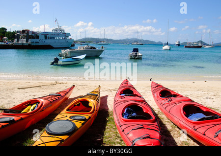 CRUZ BAY, St. John, US Jungferninseln – farbenfrohe Kajaks säumen den Strand von Christian Cove in Cruz Bay, der wichtigsten Stadt und dem Einreisehafen auf St. John auf den US Jungferninseln. Diese lebendigen Wasserfahrzeuge bieten Besuchern die Möglichkeit, die Küste zu erkunden und sich auf Wasserbasis zu entspannen und die beliebten Outdoor-Aktivitäten auf dieser karibischen Insel zu präsentieren. Stockfoto