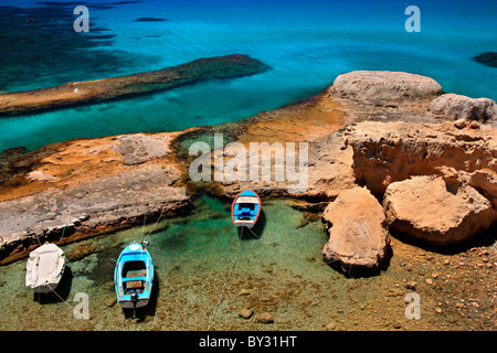 Insel Milos, Griechenland. Eine kleine natürliche "Hafen" sehr nahe Fyriplaka Strand mit Fischerbooten und kristallklarem Wasser. Stockfoto