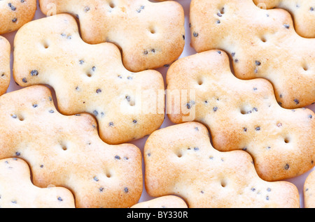 Kleine braune knackige Kekse als Kachelhintergrund geformt Stockfoto