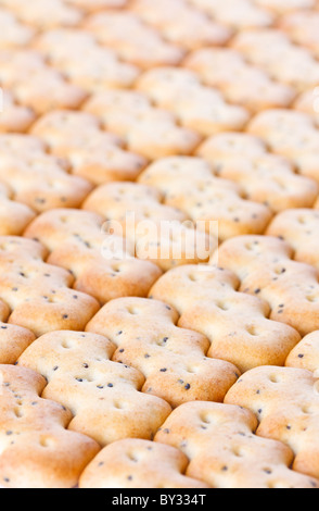 Kleine braune knackige Kekse als Kachelhintergrund geformt Stockfoto