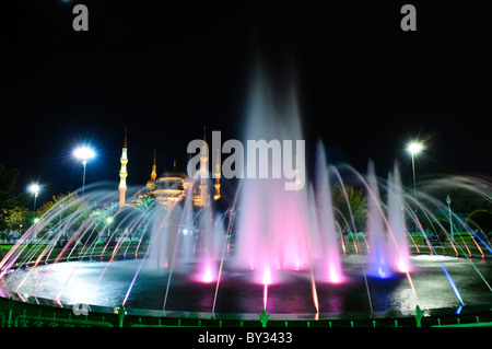 ISTANBUL, Türkei / Türkiye - beleuchteter Brunnen im Sultanahment Park mit der Blauen Moschee im Hintergrund. Sultan-Ahmed-Moschee (türkisch Sultanahmet Camii), im Volksmund als Blaue Moschee bekannt, ist eine muslimische (sunnitische) Moschee im Zentrum von Istanbuls Altstadt von Sultanahmet. Es wurde von Sultan Ahmed I. in Auftrag gegeben und 1616 fertiggestellt. Stockfoto