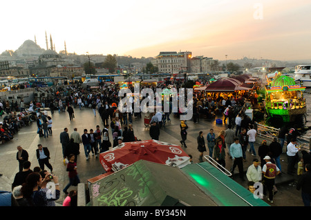 ISTANBUL, Türkei / Türkiye – Eminonu-Ufer in Istanbul bei Sonnenuntergang. Am Ufer des Goldenen Horns neben der Galata-Brücke ist ein beliebter Ort, um gegrillte Fisch-Sandwiches zu erhalten, die auf den Booten zubereitet werden, die auf dem Wasser neben dem Dock wippen. Stockfoto