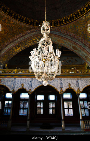 Topkapi Palast Kaisersaal Istanbul Türkei // ISTANBUL, Türkei — der Kaisersaal (Hünkâr Sofası), auch bekannt als Kaiserliches Sofa, Thronsaal oder Ablenkungshalle, ist ein gewölbter Saal im Harem des Topkapi Palastes, der vermutlich im späten 16. Jahrhundert erbaut wurde. Ein prächtiger Kristalllüster hängt von der Mitte der Kuppeldecke und beleuchtet das reich verzierte Interieur mit seinen komplizierten Mustern und vergoldeten Details. Stockfoto
