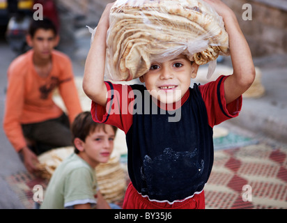 Syrischer junge tragen frisches Brot auf dem Kopf in Hama, Syrien Stockfoto