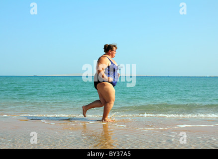 Sport - übergewichtige Frau läuft auf Meer Küste Stockfoto
