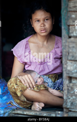 Moken Meer Zigeuner Mutter und Kind sitzt in einem Hauseingang in Süd-Thailand. Stockfoto