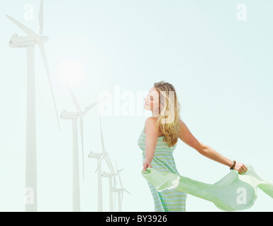 Junge Frau in der Nähe von Windkraftanlagen Stockfoto