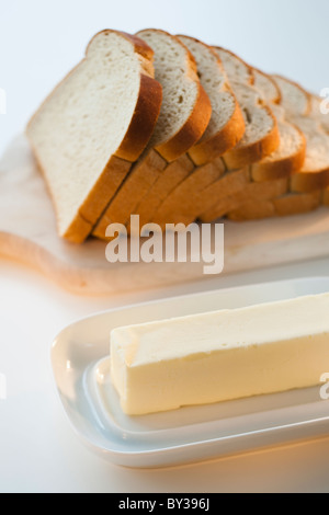 Schnittbrot auf Schneidebrett neben butter Stockfoto