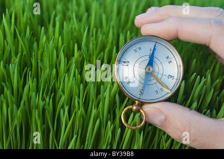 Männliche Hand Holding Kompass Gras Stockfoto