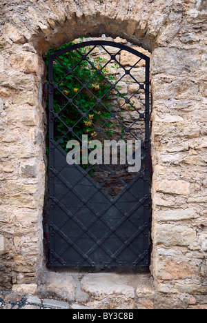 Die alte Schmiede-eisernen Tür in der Wand, aus Stein gebaut. Stockfoto