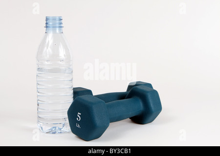 Flasche Wasser und zwei fünf-Pfund-Gewichte sitzen auf weißem Hintergrund. Stockfoto