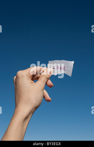 USA, Arizona, Winslow, menschliche Hand halten Liebe Hinweis gegen blauen Himmel Stockfoto