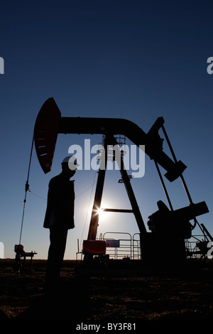 Silhouette des Öl-Arbeiter von Pumpe Jack am rig Stockfoto