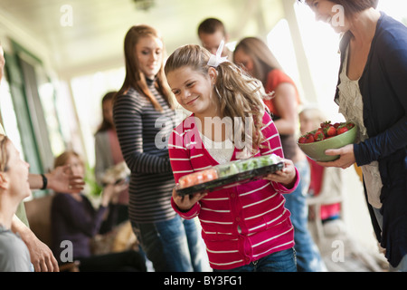 Mädchen (10-11,14-15) mit der Familie während der Feier Stockfoto