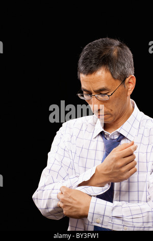 Studioaufnahme des Mannes knöpfte Manschette Stockfoto