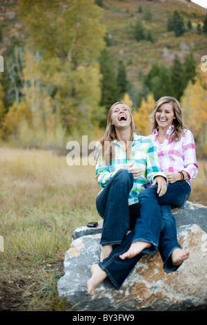 USA, Utah, Sundance, zwei junge Frauen sitzen auf Felsen und lachen Stockfoto