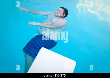 Hughson, California, Vereinigte Staaten von Amerika.  Eine übergewichtige Teenager schwebt in einem Schwimmbad. Stockfoto