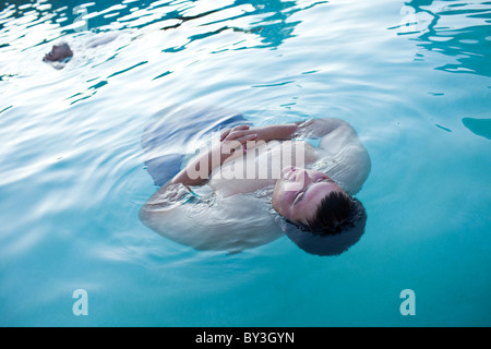 Hughson, California, Vereinigte Staaten von Amerika.  Eine übergewichtige Teenager schwimmt im Pool. Stockfoto