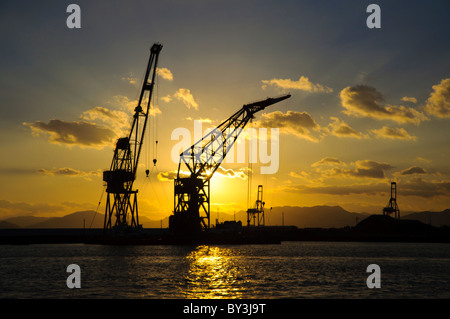 Blick auf den Sonnenuntergang (Landschaft / Seestück) Derrick Krane auf Kais an ein Industriehafen in Asien Stockfoto