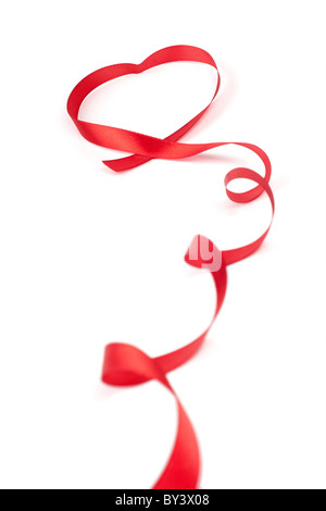 Red Ribbon eingerollt in Herzform isoliert auf weißem Hintergrund Stockfoto