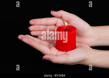 Hand hält Burninging Kerze in der Dunkelheit Stockfoto