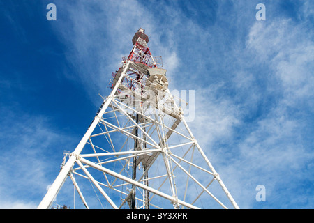Fernmeldeturm mit Antennen vor blauem Himmelshintergrund Stockfoto