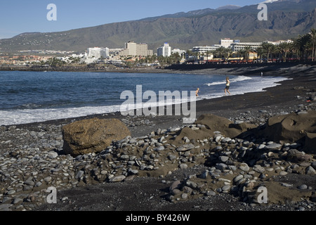 Schwarzer Strand entlang der Strandpromenade von Playa de Las Americas, Teneriffa, Kanarische Inseln, Spanien Stockfoto