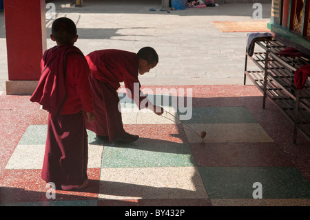 junge tibetische-Sherpa Mönche ein Kreisel in einem Kloster bei Bodhnath in Kathmandu, Nepal Stockfoto