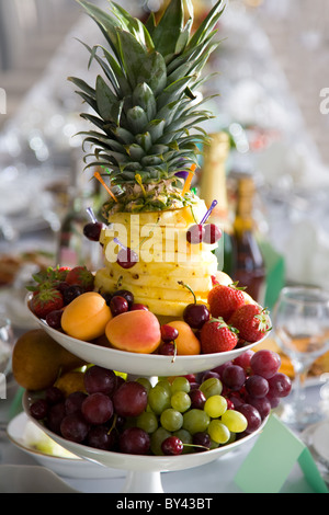 Mischung aus verschiedenen Früchten und Beeren auf Tellern im Rahmen der Hochzeitstafel Stockfoto