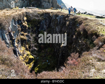 CWM Wimpel, Gwynedd, Nordwales, UK. Wanderer durch einen alten Minenschacht in stillgelegten Schieferbergwerk in Snowdonia-Nationalpark Stockfoto