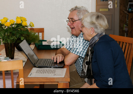 Älteres Ehepaar ihren Laptop benutzen Skype Freunde über das Internet aus ihrer Heimat Stockfoto