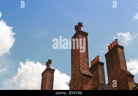 2 rote Backstein-Schornsteine mit roten Schornstein gegen blauen Himmel